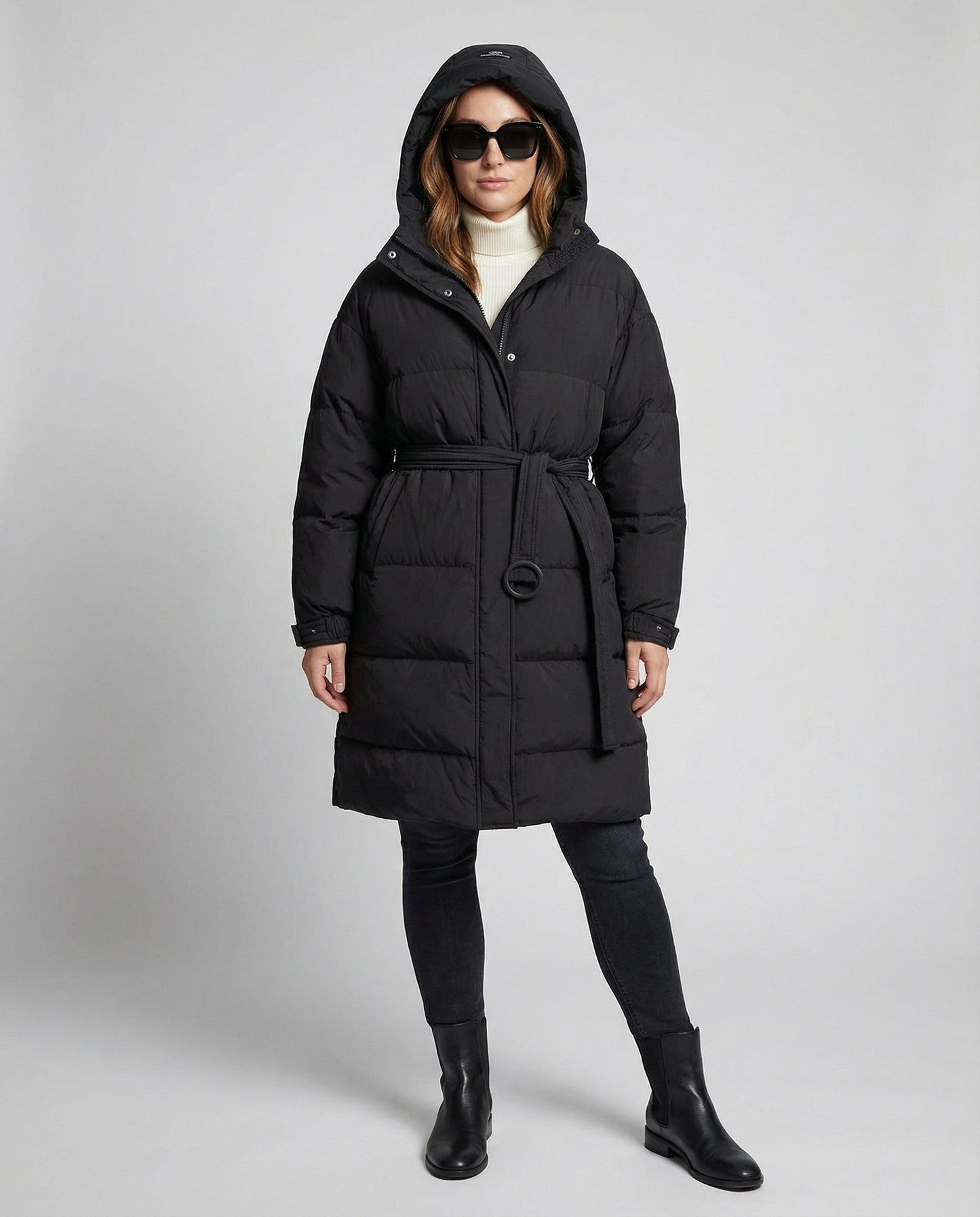 Person wearing a black puffer coat on a gray background