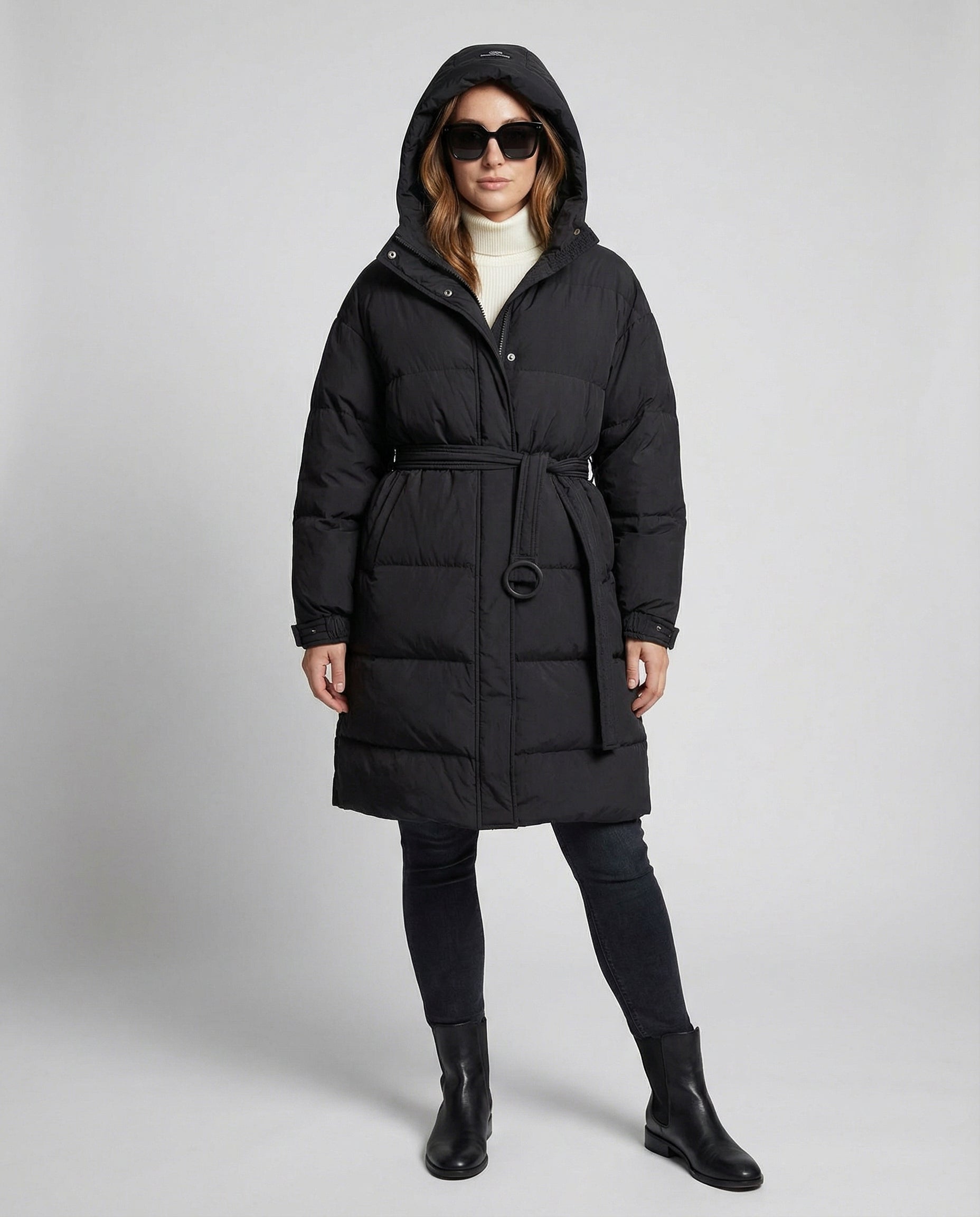 Person wearing a black puffer coat on a gray background