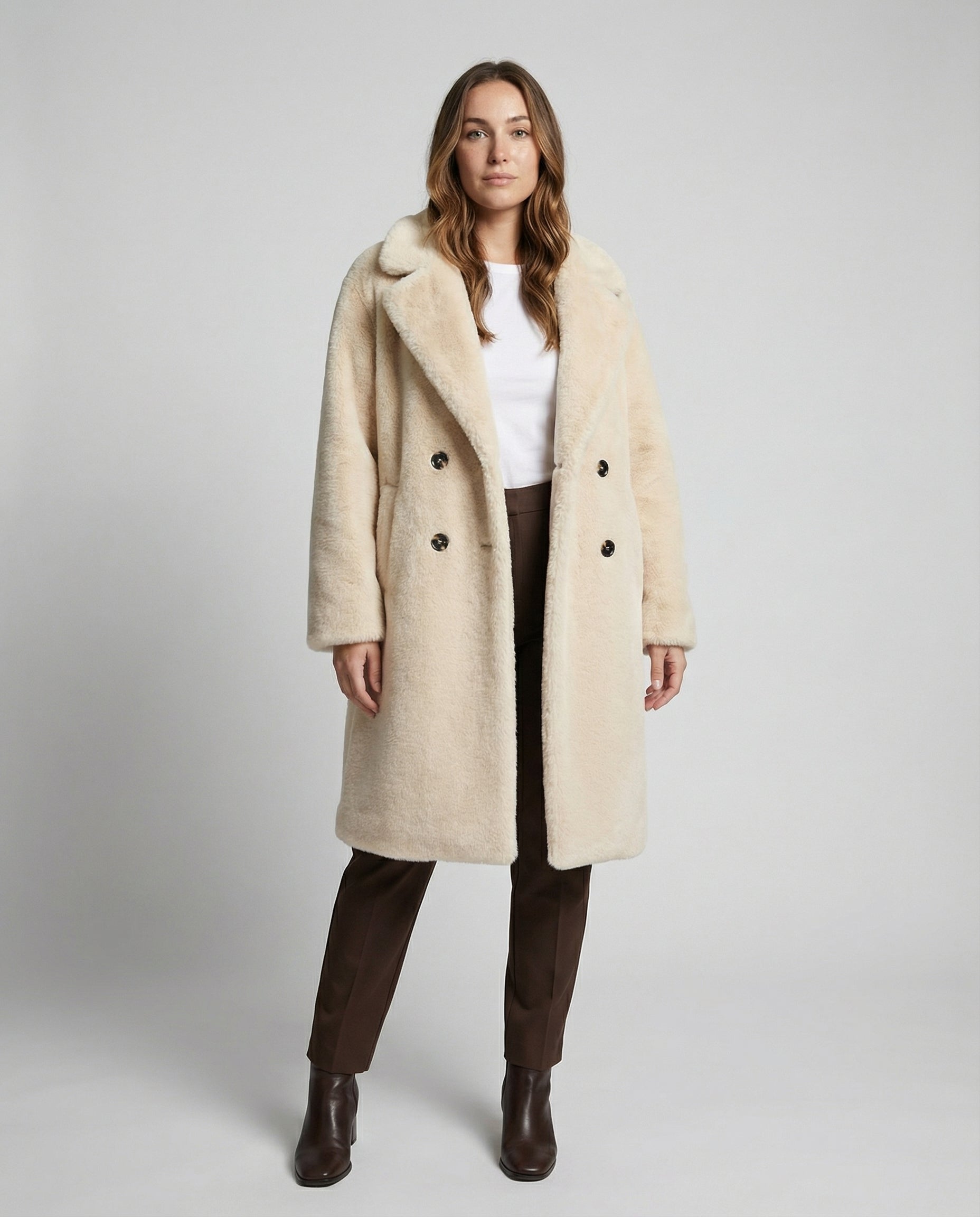 Woman wearing a beige coat on a plain background