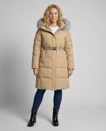 Woman wearing a beige puffer coat with fur hood on a gray background