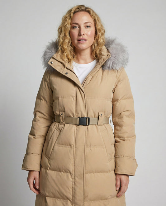 Woman wearing a beige winter coat with a fur-lined hood on a plain background